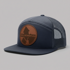 Navy blue cap with brown leather patch on a white background