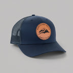 Navy blue cap with a brown leather patch on a light gray background