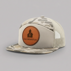 Beige and camouflage cap with a brown leather patch on a white background