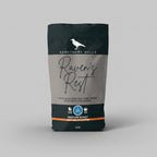 Coffee bag labeled 'Raven's Rest' from Sanctuary Hills on a gray background