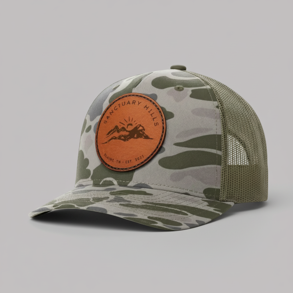 Camouflage baseball cap with leather patch on a white background